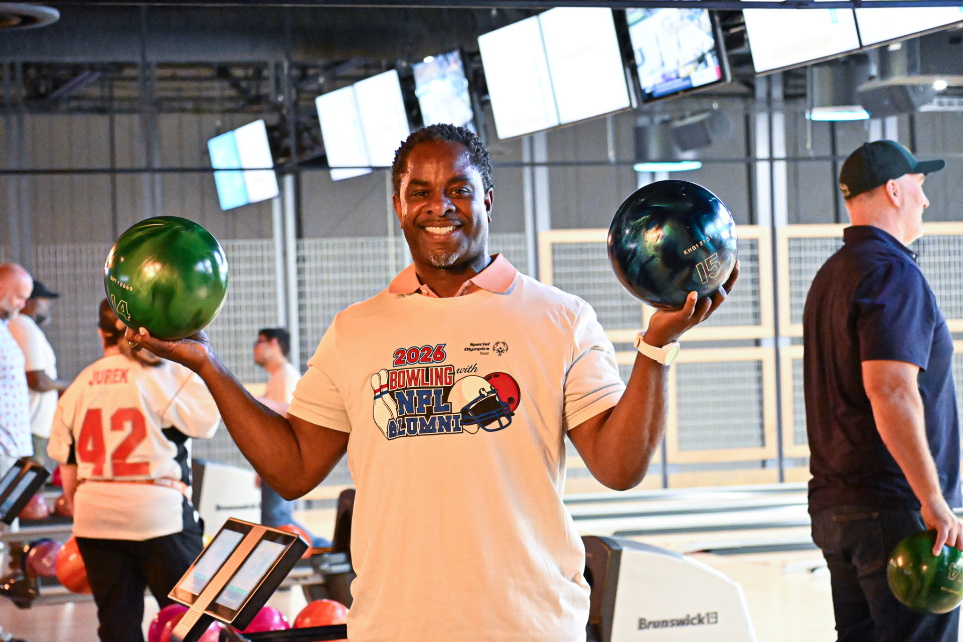 Rodrick Walker holding bowling balls at the NFL Alumni charity event