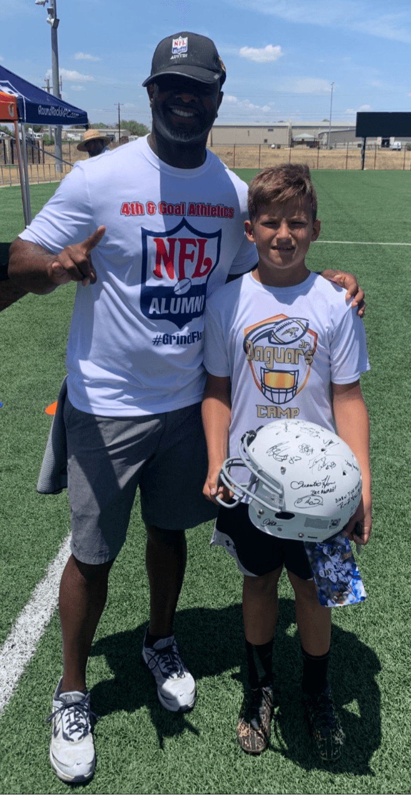 Rodrick Walker with a young camper at an NFL Alumni football camp