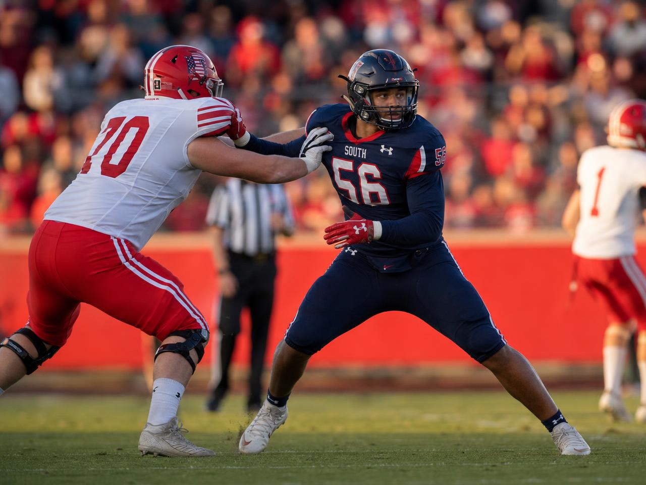 A linebacker shedding a block with strong hands and leverage